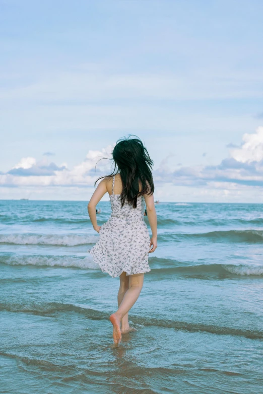 a person walking on the sand near a body of water