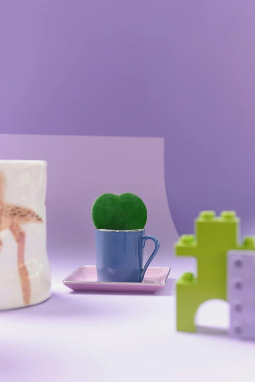 two colorful coffee cups and one with green plant