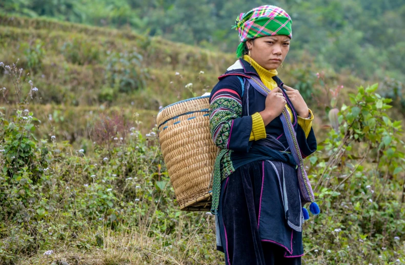 a woman in a hat is holding a basket