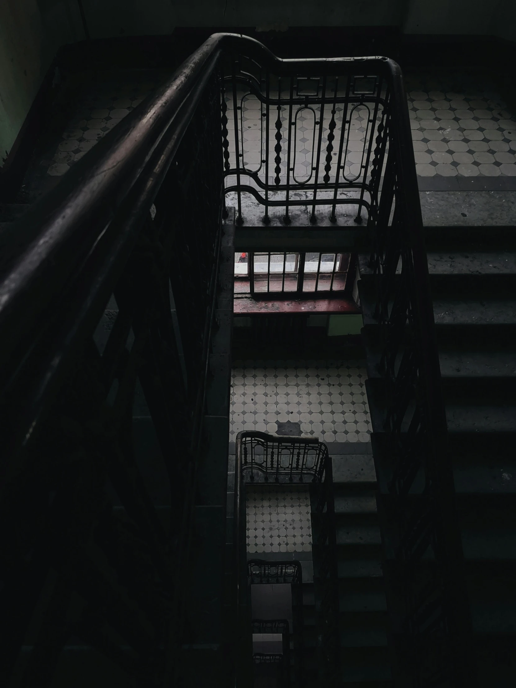 the stairs in a dark building have bars going down