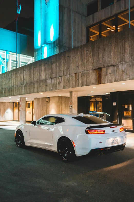 the front of a white sports car on a city street