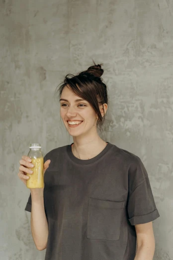the smiling woman holds up a glass of drink