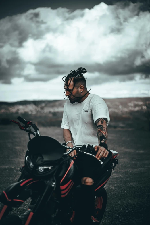 a man wearing all white with a motorcycle looking at the camera