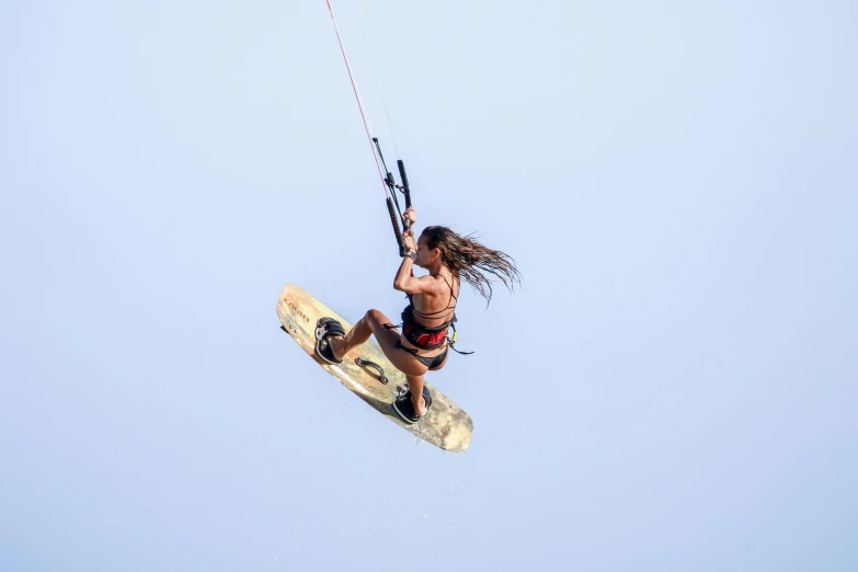 a woman is using a kite to glide on a body of water