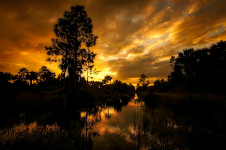 a sunset scene with a canal in the foreground