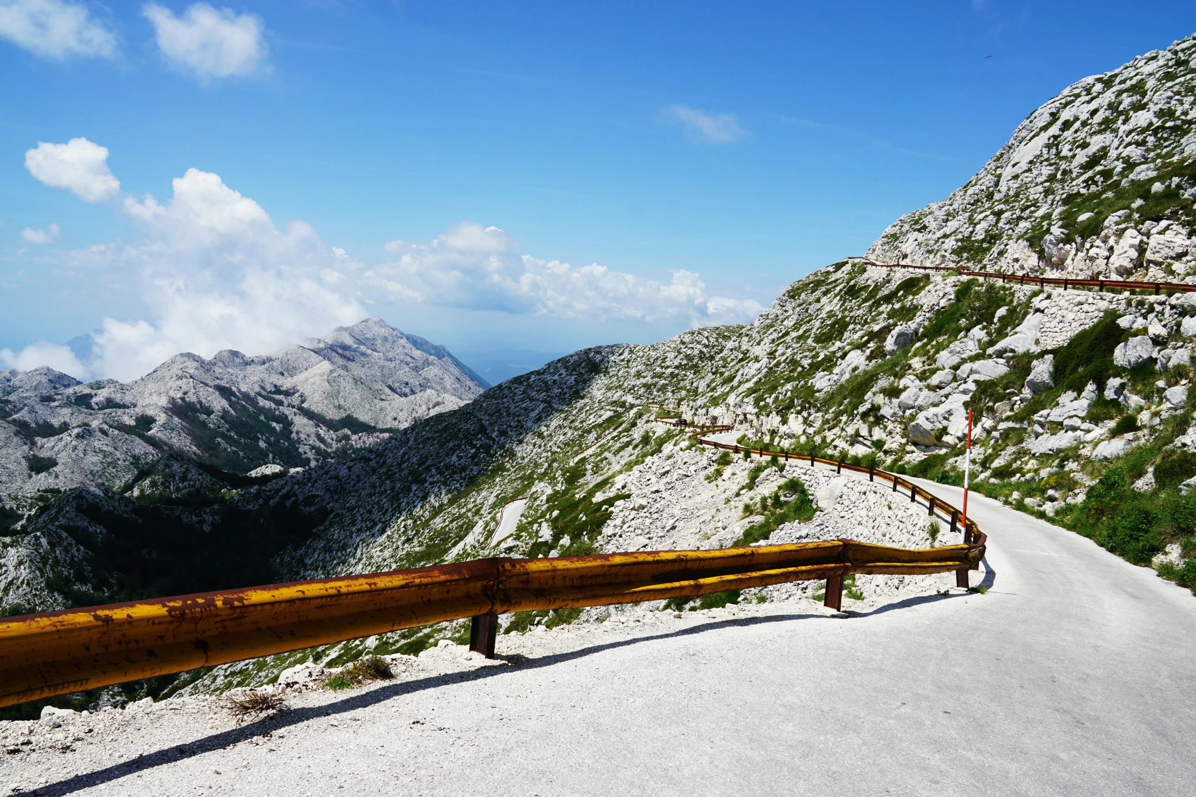 a wooden object that is in the middle of a mountain road