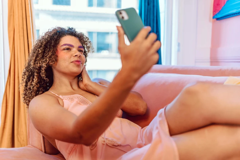 a woman in pink shirt sitting on pink couch