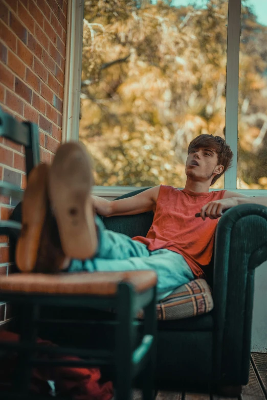 a man sitting in a chair looking out of a window