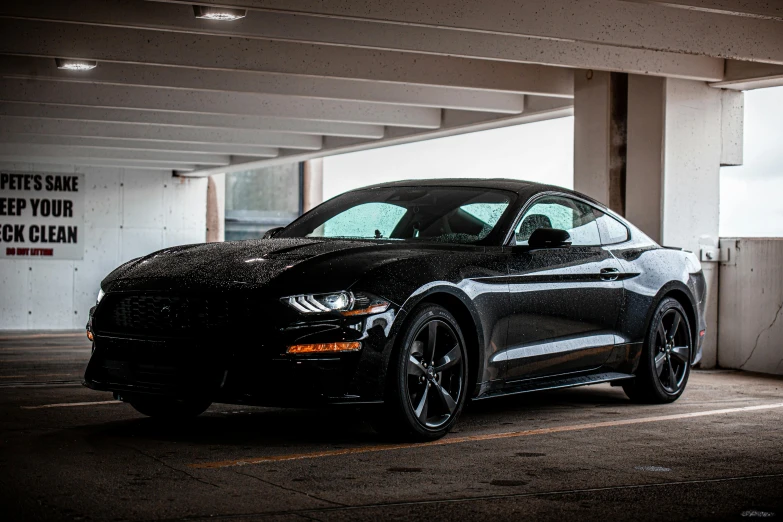 the large, shiny ford mustang is parked in a garage