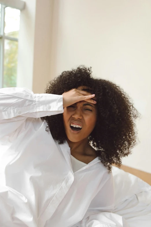 the woman in white is laughing and covering her eyes