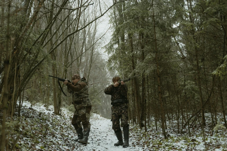 the two men in the woods are hunting