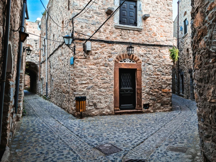 an alleyway with a brown door and brick building