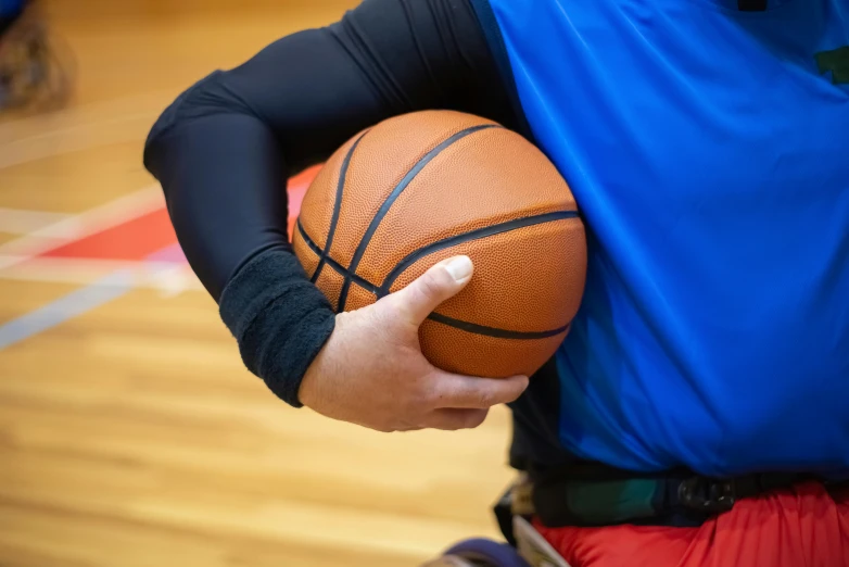 basketball player holding a basketball over his shoulders