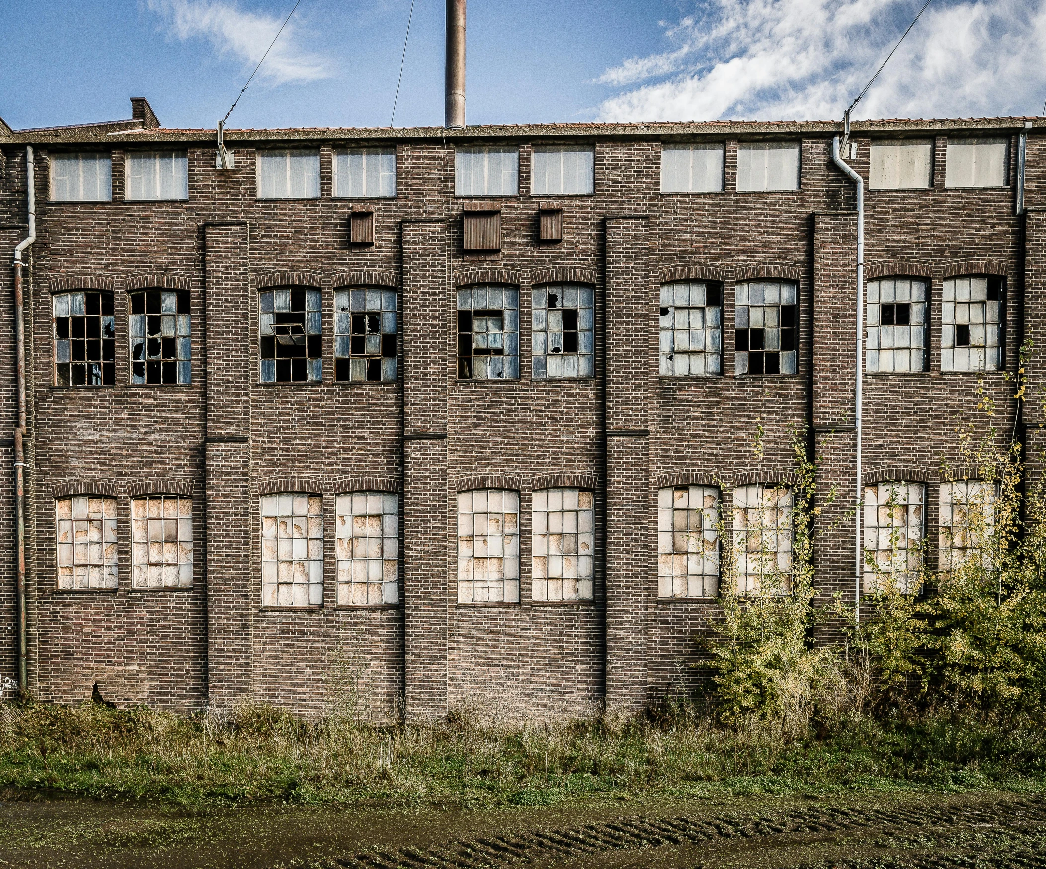 an empty road in front of a brick building