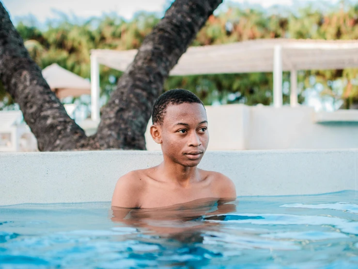 an african american male sitting in a swimming pool