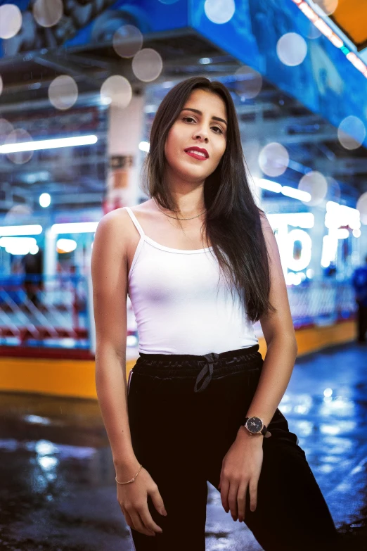 a woman in black and white clothing stands in front of a subway