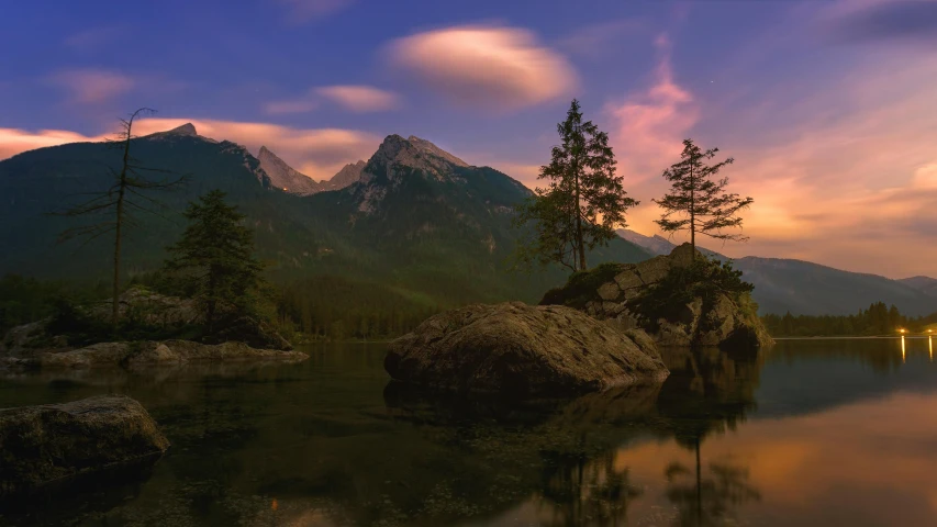 a mountain lake near some rocks and trees