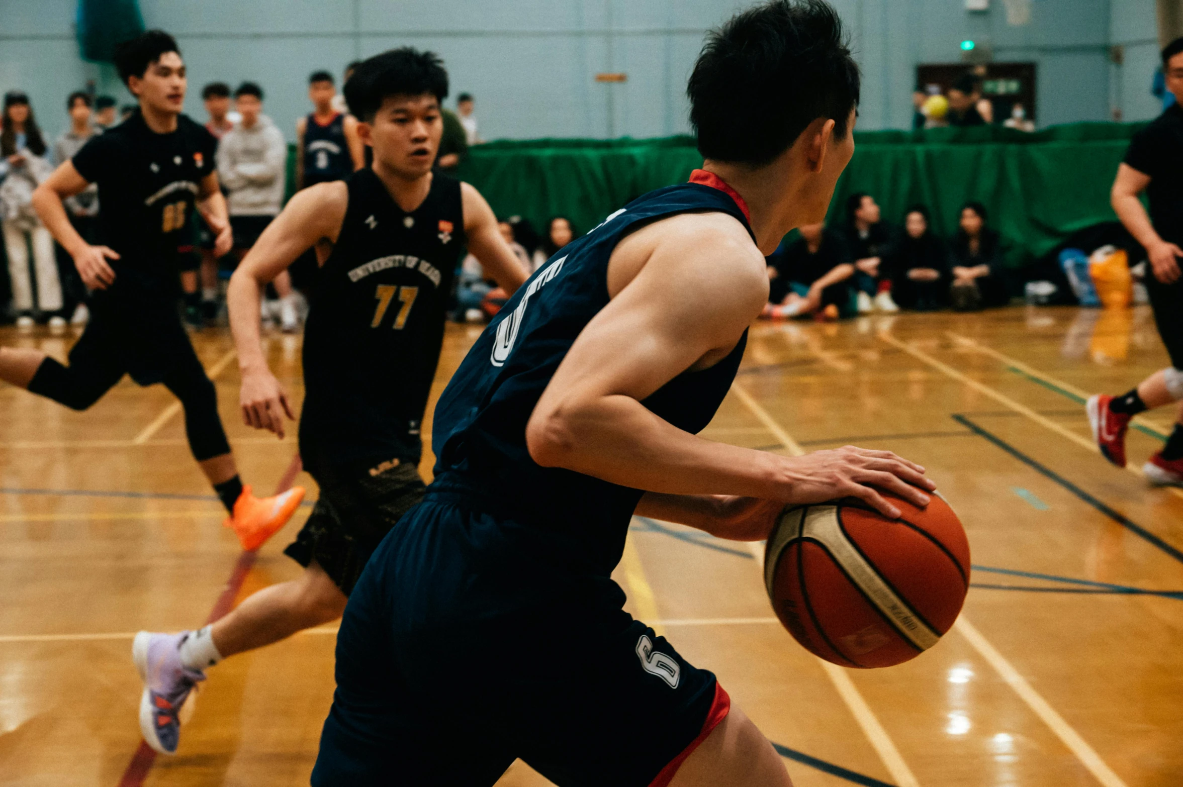 boys in uniforms are playing basketball on an indoor court