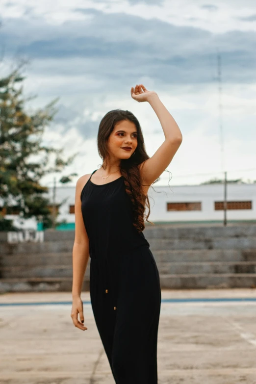 the woman with the fist is posing in her black jumpsuit