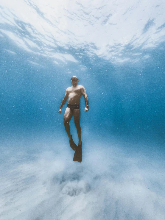 a man swims in the water near the bottom of the ocean