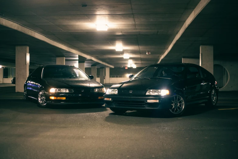 a parking garage with parked cars and a couple of people inside