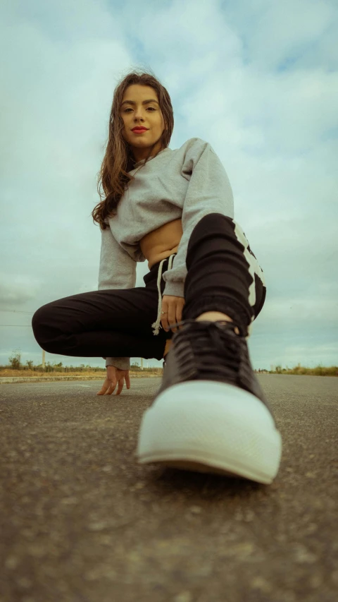 a young woman sitting on top of her sneakers