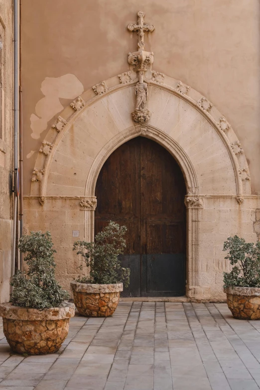 the door to an old building with two stone planters