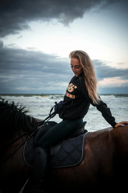 a beautiful woman riding on the back of a brown horse