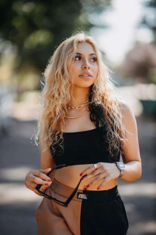 a woman in black top and tan shorts looking off into the distance