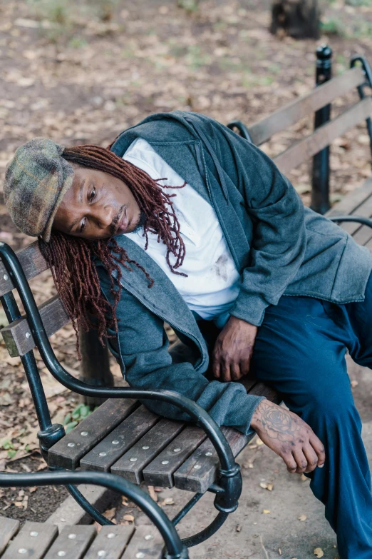 an african american man with dreadlocks and dread locks sleeping on a park bench