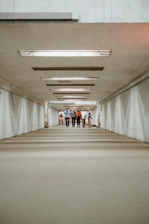 group of people walking down bridge in daytime