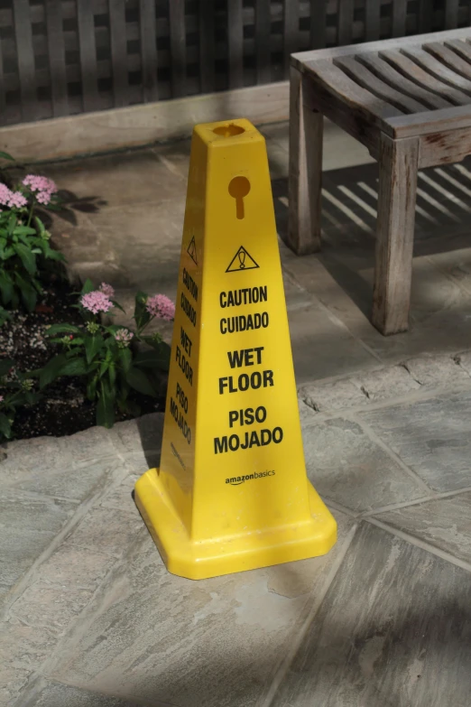 a yellow caution cone sitting on top of a sidewalk