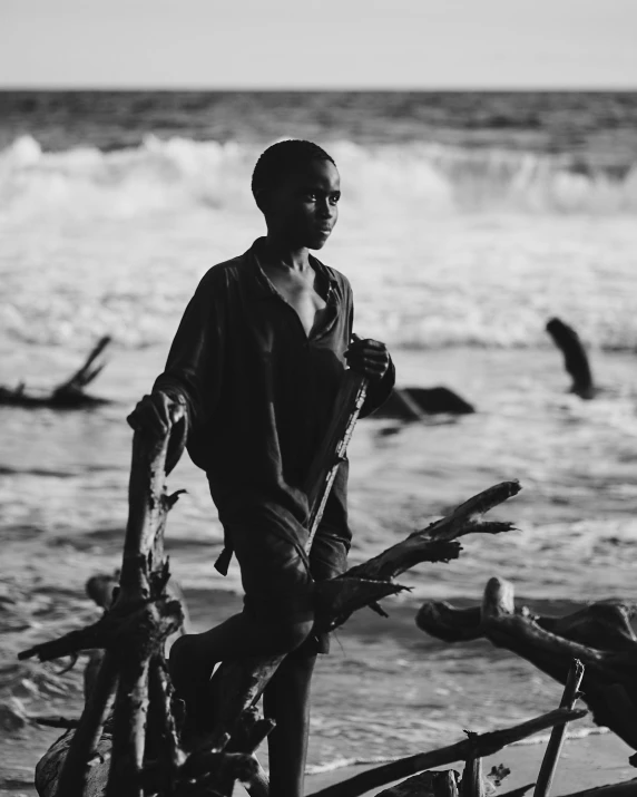 a black and white po of a boy standing on the beach