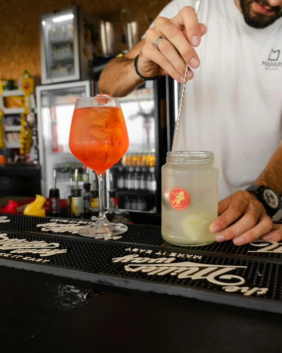 a man pours a drink into a glass