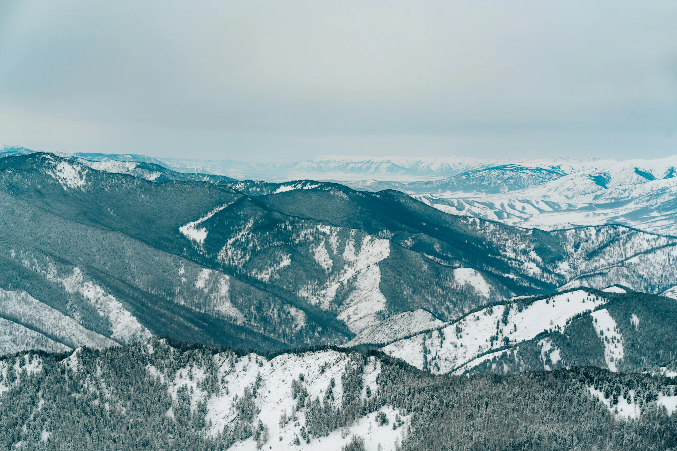 snowy mountain tops in a snowy day taken from the top