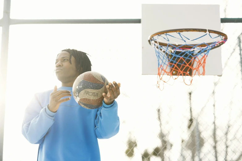 a man holding a basketball near a net