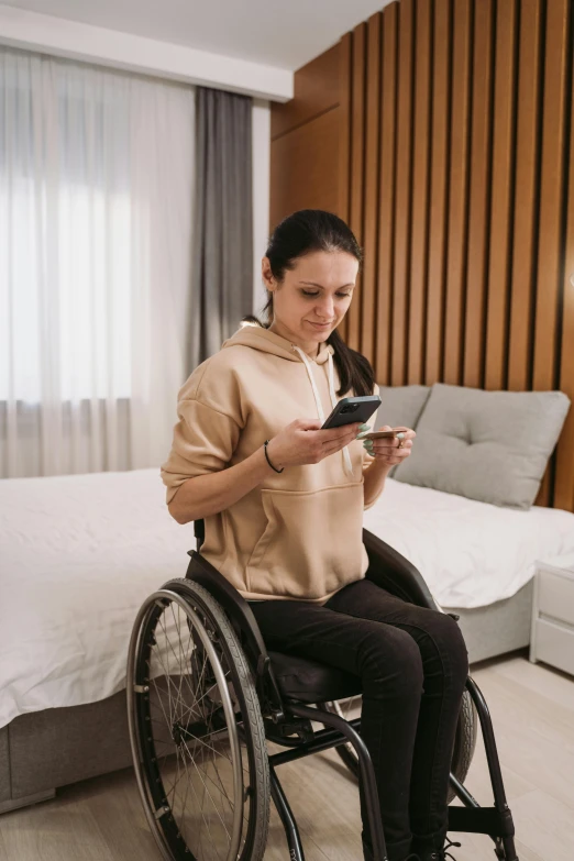 a woman in a wheelchair looking at her cell phone