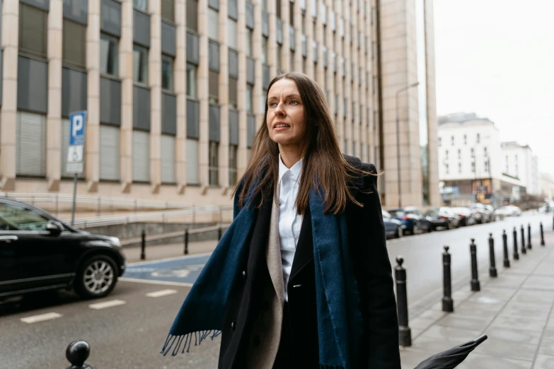 a woman walking down the street by a building