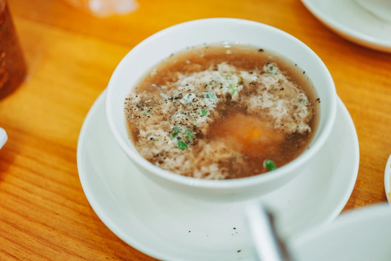 a soup dish with lots of meat in it sitting on a saucer