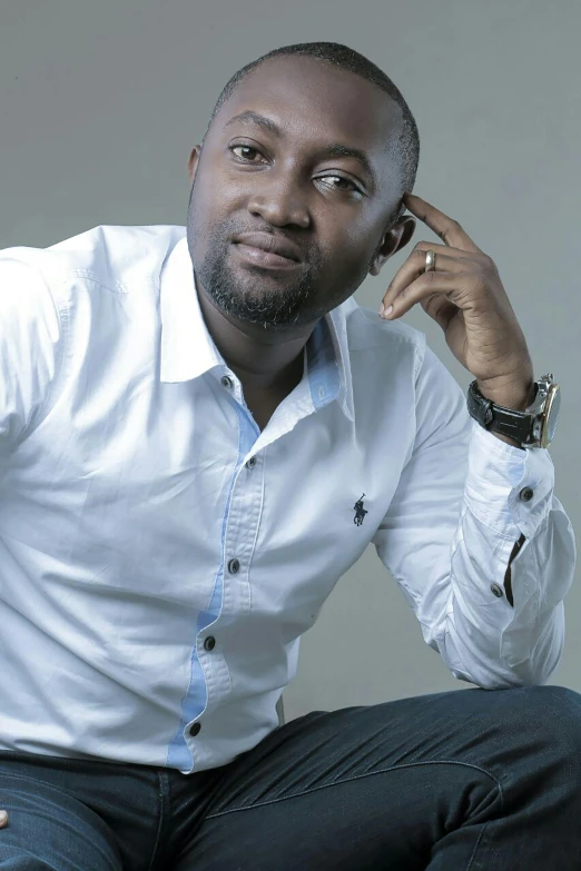 an african man poses with a phone in his hand