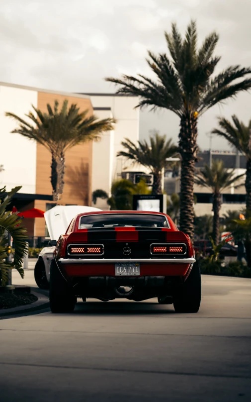 an image of a red car driving through the parking lot