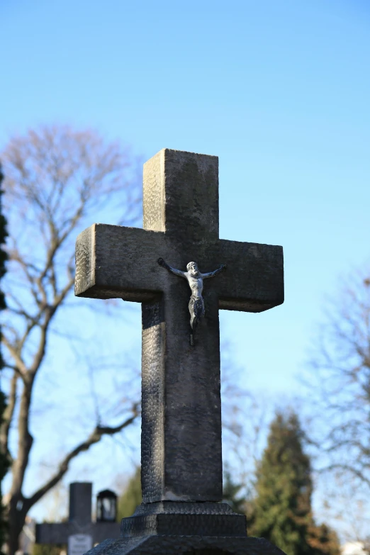 a cross sits with a statue of a person in the middle