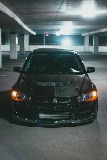 a black car in a parking space at night