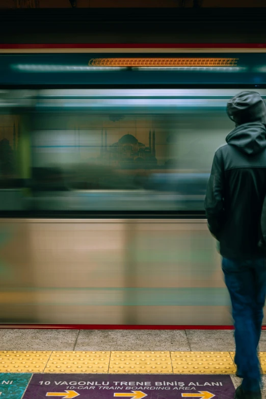 the man is waiting for a subway train at the station