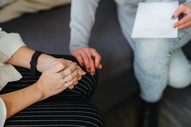 two people sitting down and one is holding her hand