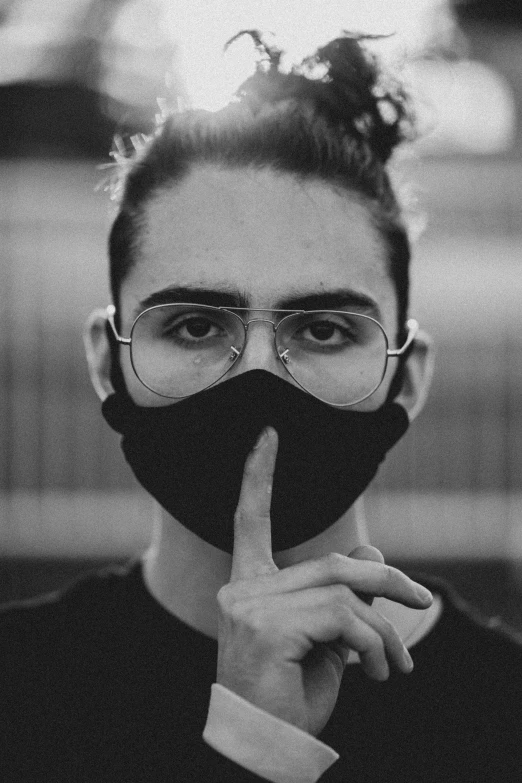 a young woman has a black cloth face mask to her mouth