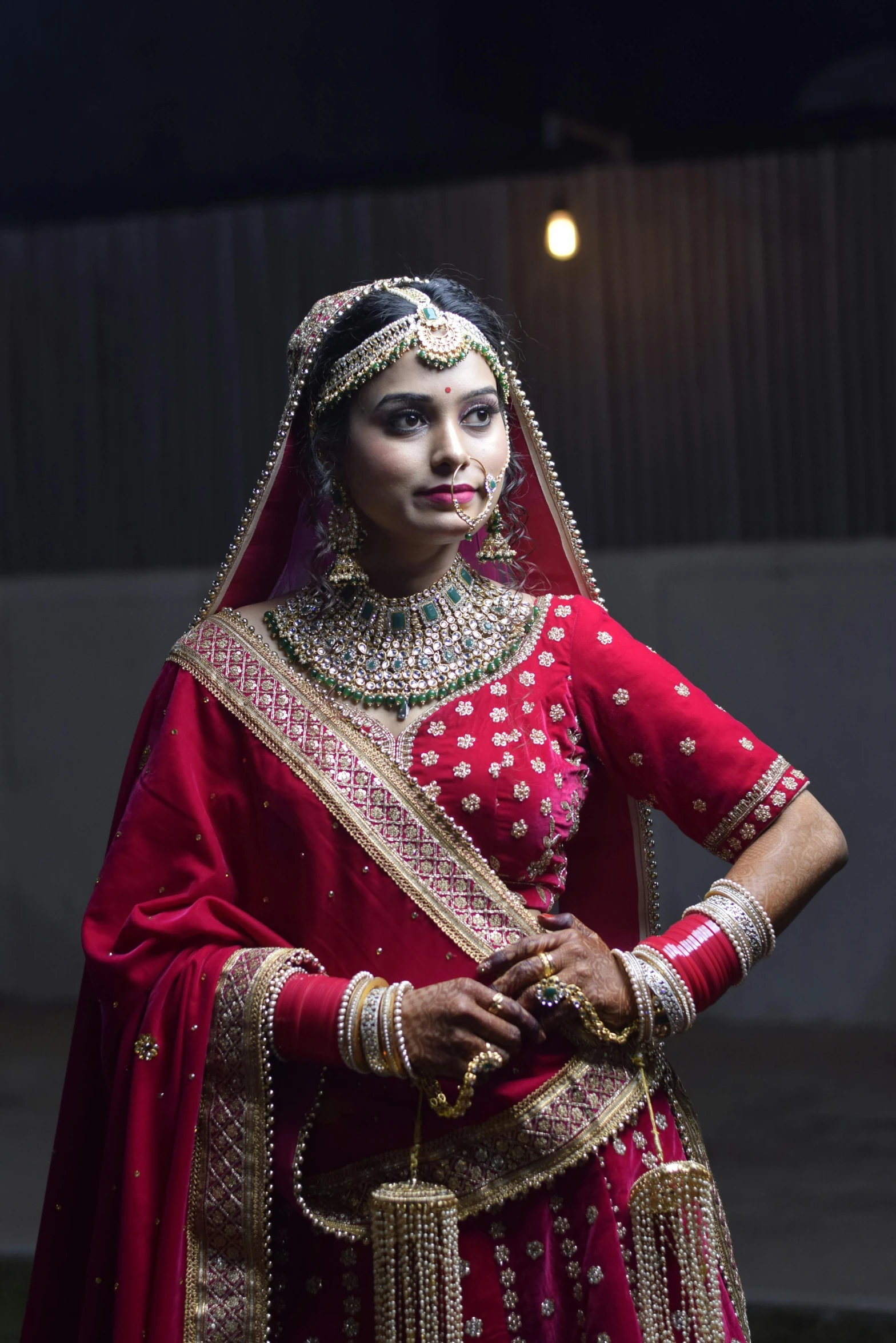 a woman wearing a red and gold indian wedding outfit