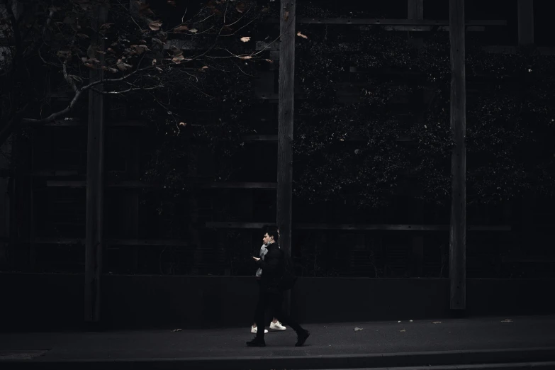 a man walking down the sidewalk under an umbrella