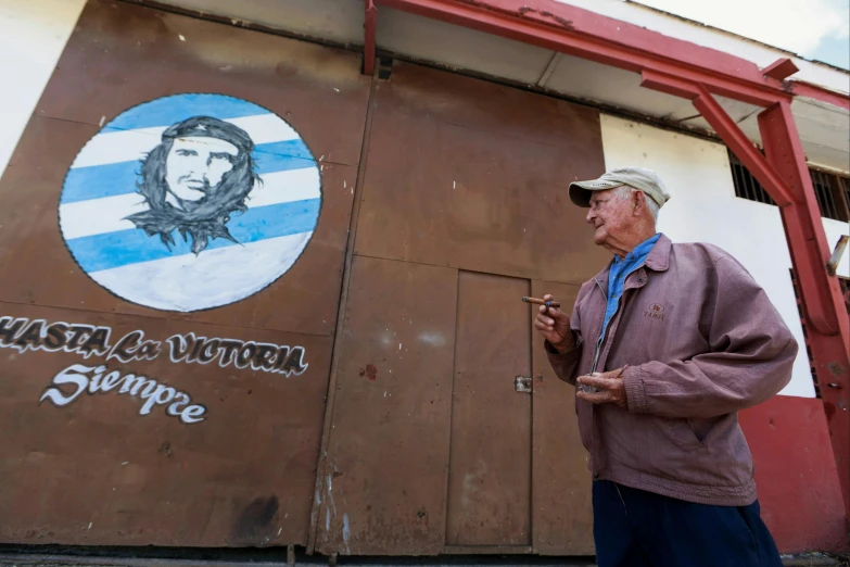 a man standing in front of a mural with a jesusic picture