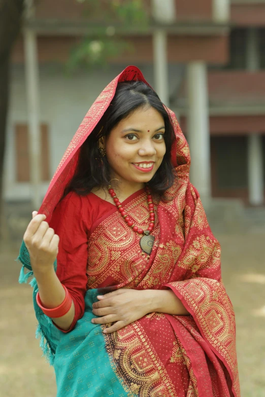 woman with red sari and a green blouse smiling
